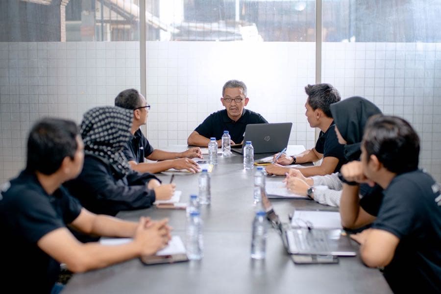 Indonesian colleagues in a team meeting reviewing a funding document together
