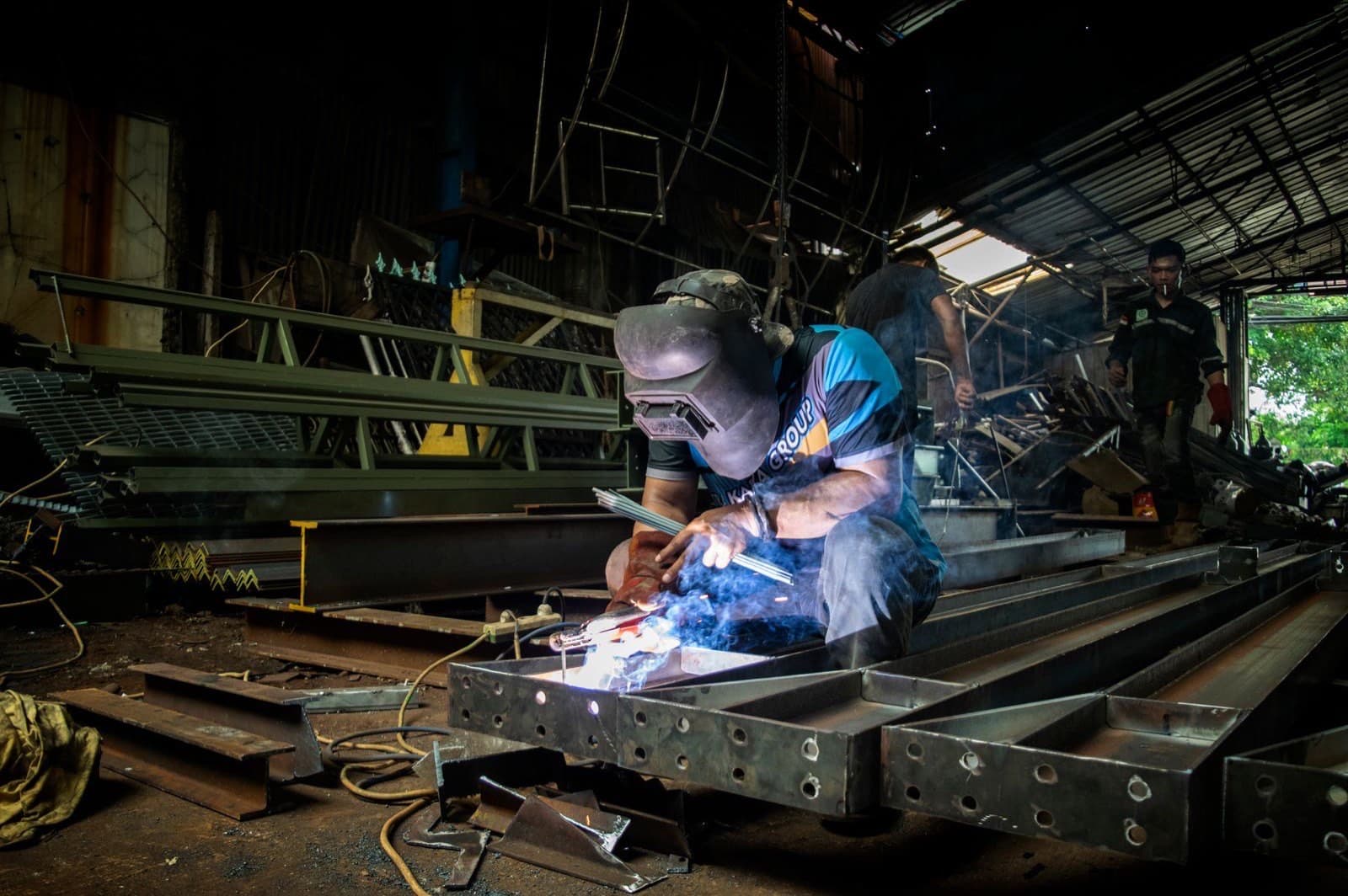 Indonesian metalworker fabricating steel components in a small manufacturing workshop